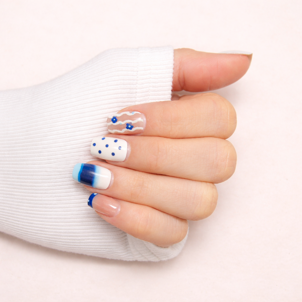 Ongles press-on Bleu Klein Fleuri sur main – manucure bleu intense avec motifs floraux élégants