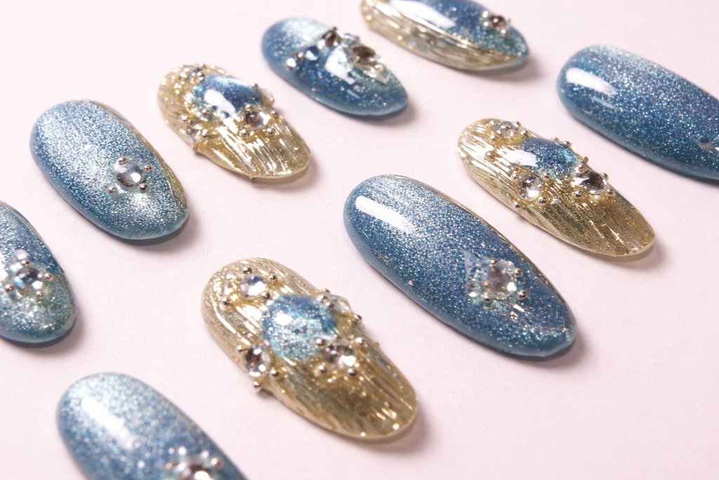 Bleu Céleste – détail faux ongles press-on bleu pailleté avec ornements dorés | MB Beauty