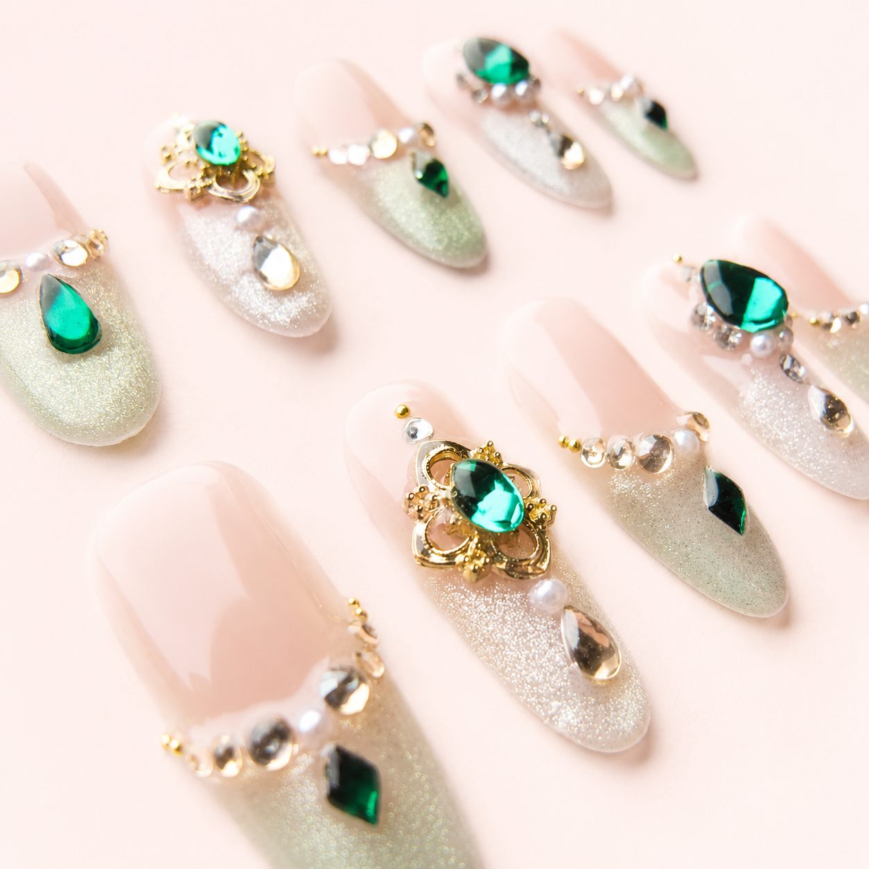 Détails bijoux vert émeraude dorés et nacrés des faux ongles press-on Éclat d’Émeraude
