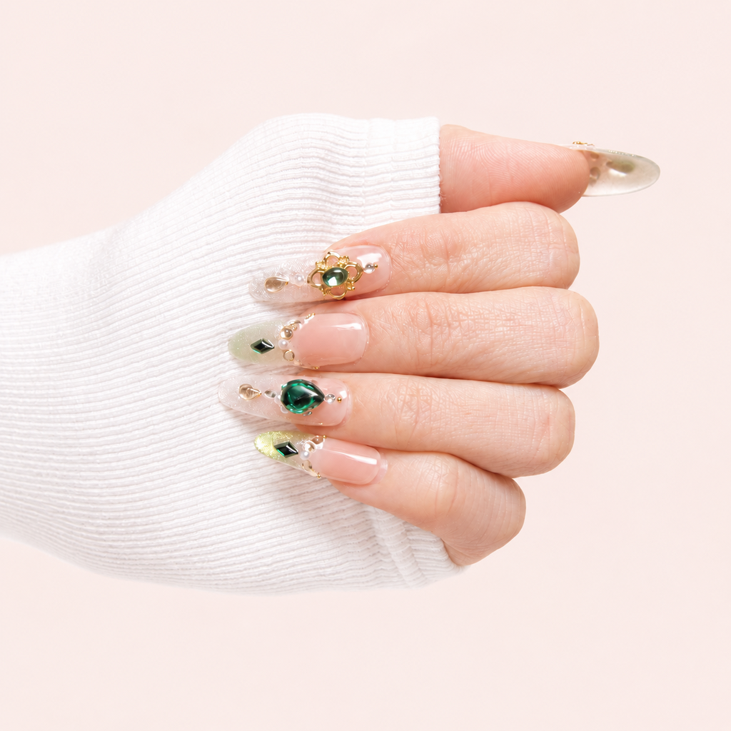 Éclat d’Émeraude faux ongles press-on nude verts bijoux portés sur la main