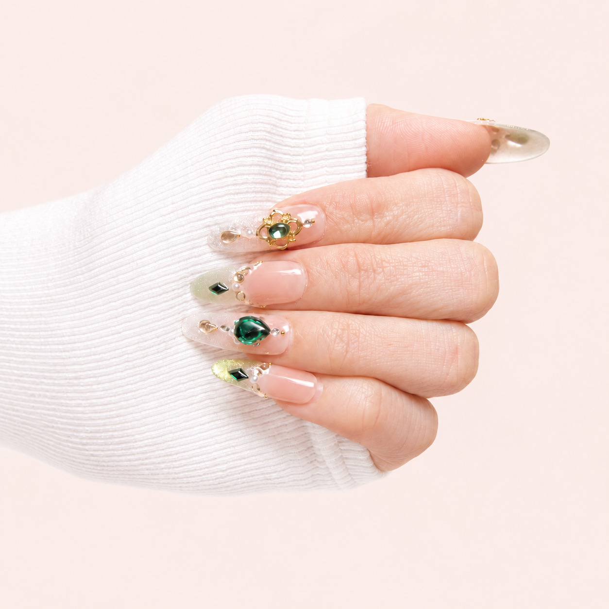 Éclat d’Émeraude faux ongles press-on nude verts bijoux portés sur la main